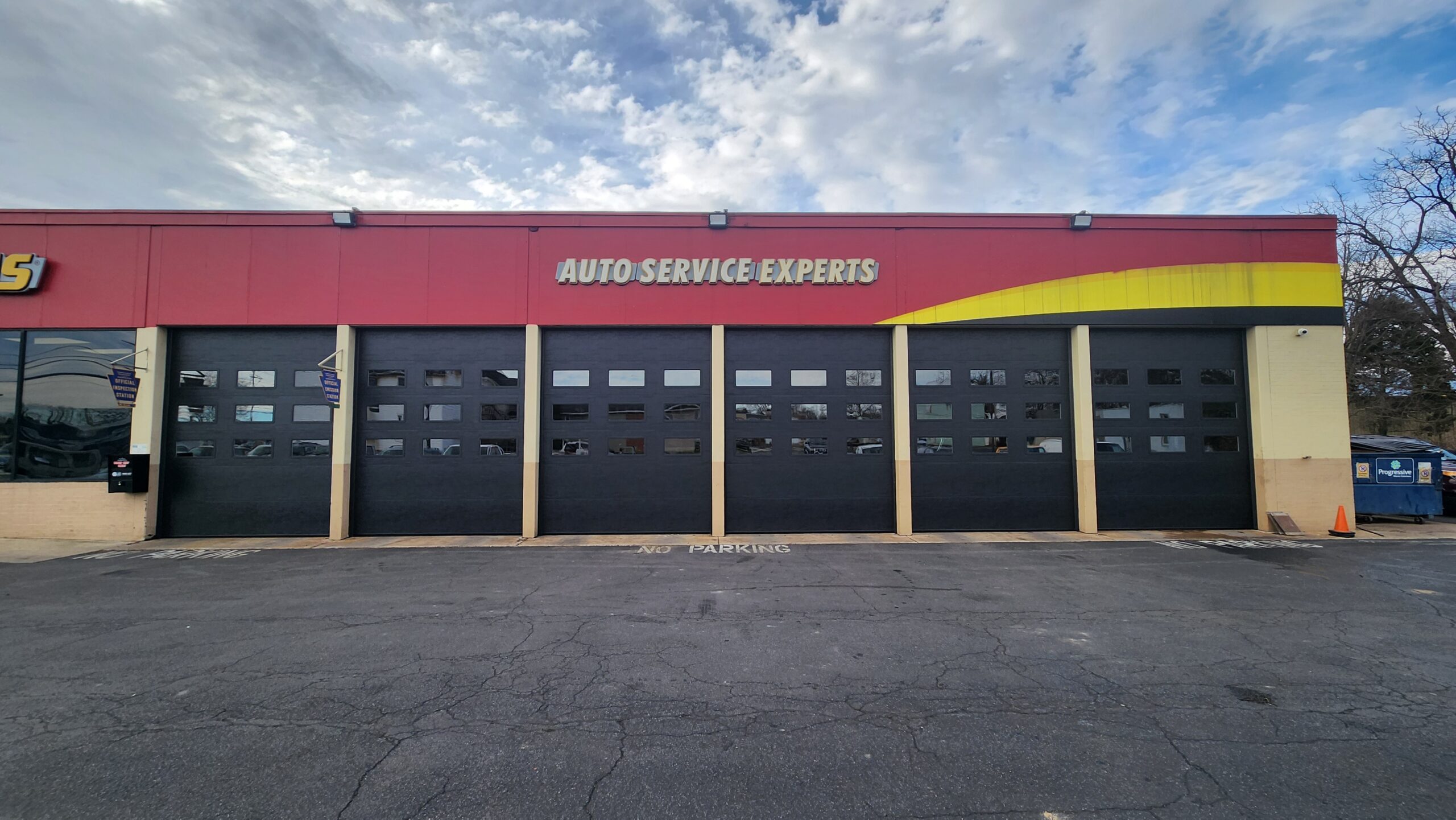 view in front of Midas commercial building with new commercial garage doors replaced by Interstate Garage Doors company